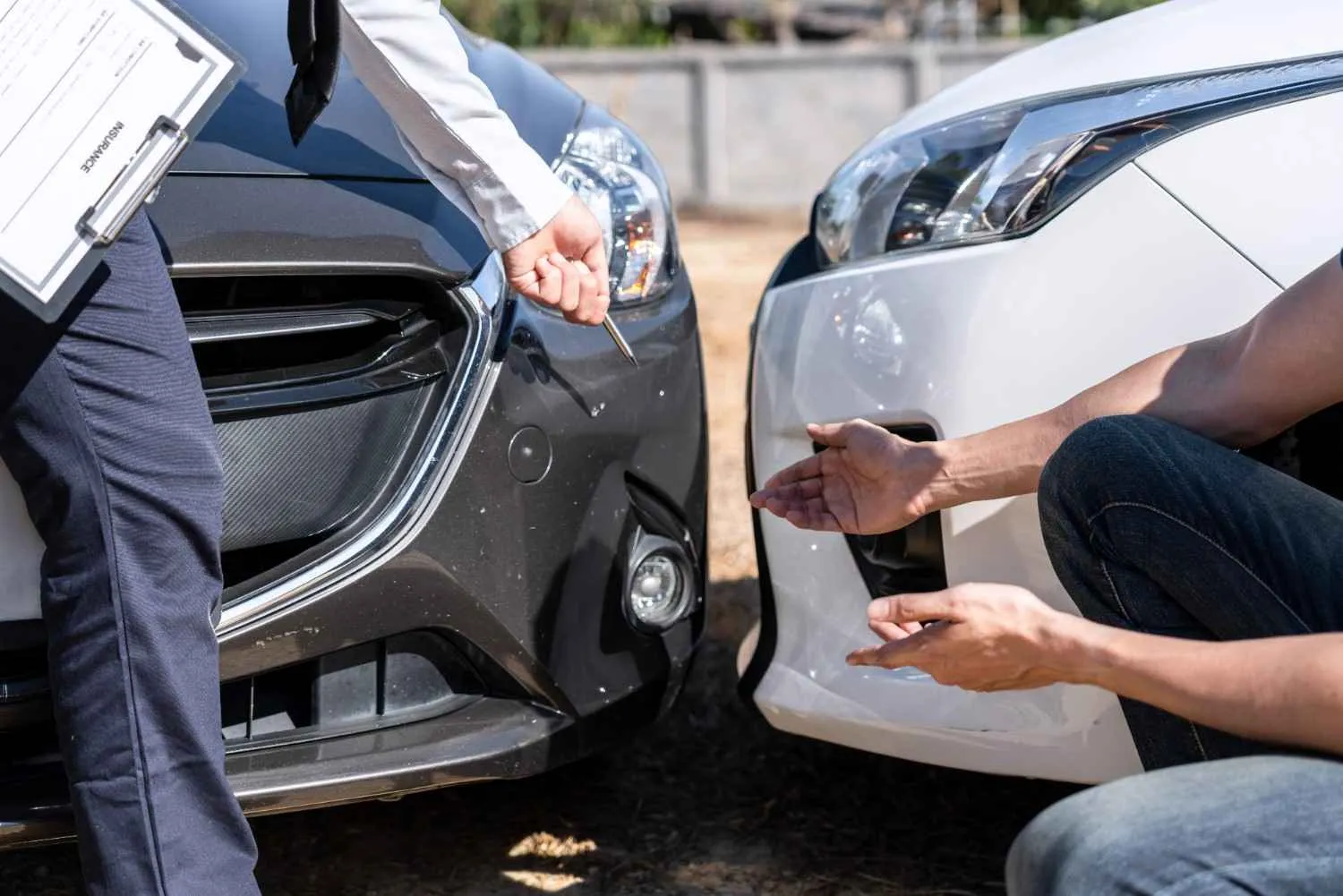 Two people checking the damage after a minor car collision